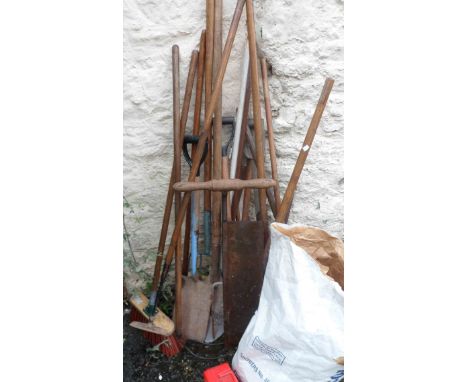 A quantity of garden tools including rakes, brushes, spade, etc.