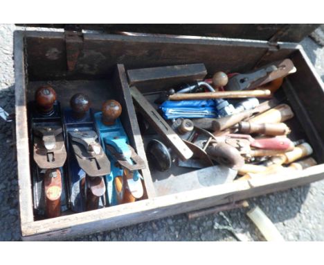 A wooden lift-top toolbox containing a quantity of tools including planes, etc.