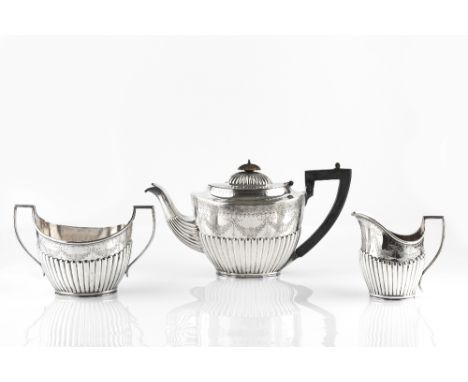 AN EDWARDIAN SILVER THREE PIECE TEA SERVICE, of oval half lobed form, engraved with swags of flowers, the teapot with ebonise