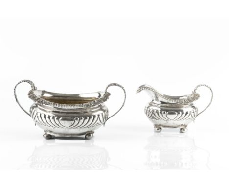 A GEORGE III SILVER TWIN HANDLED SUCRIER AND MATCHING MILK JUG, with gadrooned and scallop cast borders, and foliate cast han