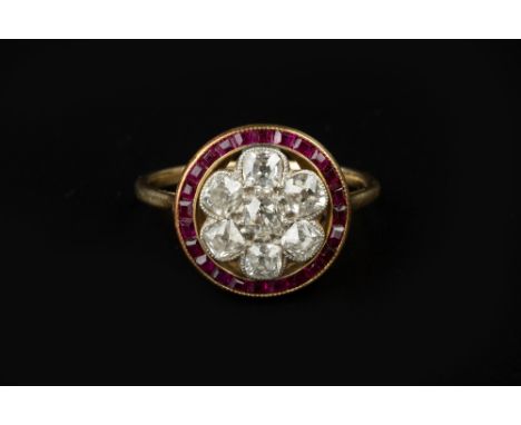 A RUBY AND DIAMOND CLUSTER RING, centred with a cluster of cushion-shaped old-cut diamonds in millegrained collet settings, t