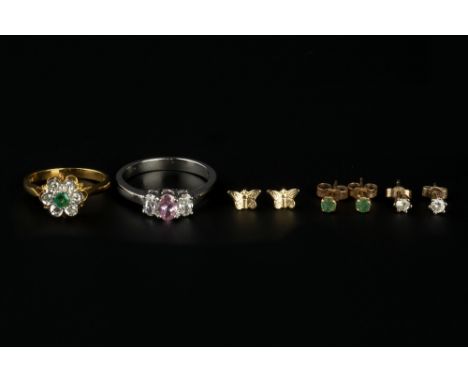 AN EMERALD AND DIAMOND CLUSTER RING, of flowerhead design, the circular mixed-cut emerald bordered by single-cut diamonds, 18
