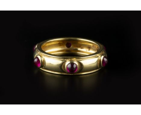A RUBY BAND RING BY TIFFANY &amp; CO, spaced with circular cabochon rubies in collet settings, yellow precious metal mounted,