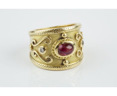 A RUBY AND DIAMOND DRESS RING, the tapered band centred with an oval cabochon ruby and two round brilliant-cut diamonds in co