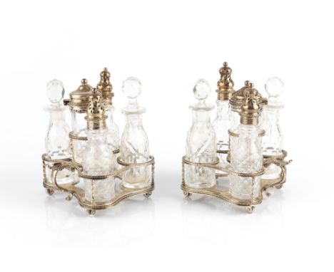 A PAIR OF  SILVER FIVE SECTION CRUET STANDS, each fitted with cut glass bottles and jars, with beaded frames and shaped bases
