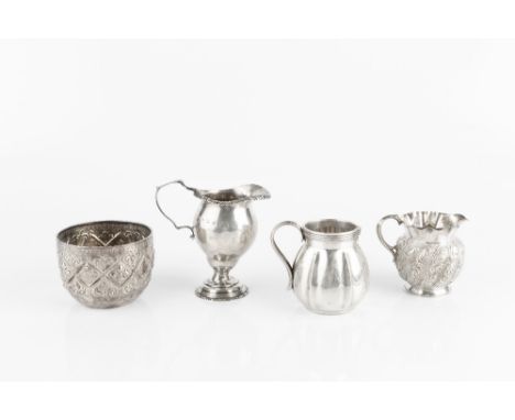 AN EDWARDIAN SILVER PEDESTAL CREAM JUG with gadrooned borders, Birmingham 1901; two further silver cream jugs; and a late Vic