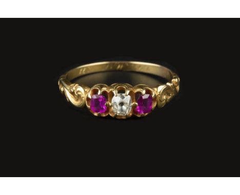 A VICTORIAN RUBY AND DIAMOND THREE STONE RING, the cushion-shaped old-cut diamond claw set between two similarly shaped rubie