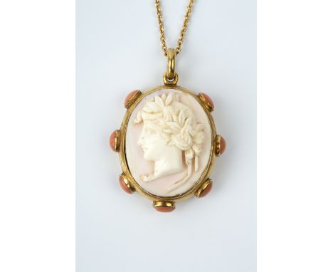 A VICTORIAN CAMEO PENDANT, the oval conch shell cameo carved to depict a classical portrait profile, bordered by oval coral c