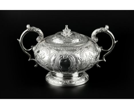 A GEORGE III SILVER TWIN HANDLED SUCRIER AND COVER, embossed with 'C' scrolls and flowering foliage, and having foliate cappe