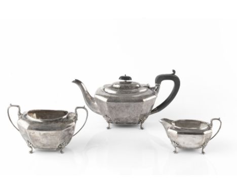 A SILVER THREE PIECE TEA SERVICE, of faceted design on cabriole legs, the teapot with ebonised handle and knop, by Henry Matt