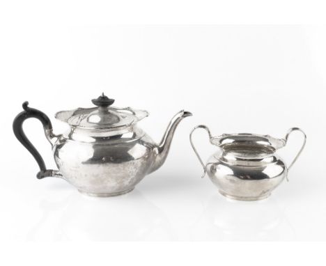 A SILVER TEAPOT, of shaped oval form, with ebonised handle and knop, and matching twin handled sucrier, by Thomas Bradbury &a