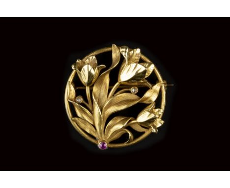 A RUBY AND DIAMOND SET PANEL BROOCH, the circular panel designed as an openwork floral spray with sinuous foliage, accented w