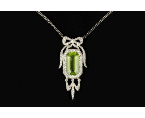 A PERIDOT AND DIAMOND PENDANT NECKLACE, the rectangular step-cut peridot bordered by rose-cut diamonds and surmounted by a si