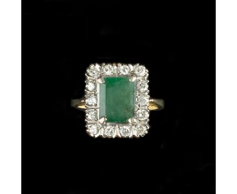 AN EMERALD AND DIAMOND CLUSTER RING, the rectangular step-cut emerald claw set within a border of round brilliant-cut diamond