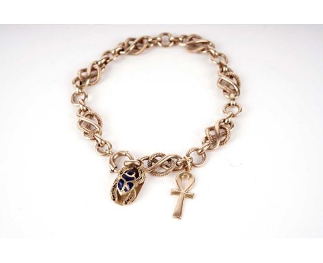 A yellow gold fancy link chain bracelet, formed of intertwined infinity and twist link chains, with Ankh and scarab beetle ch