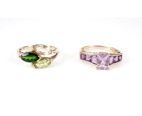 An amethyst seven-stone dress ring, in 9ct yellow gold; and a green three-stone dress ring, in 9ct yellow gold, each size S, 