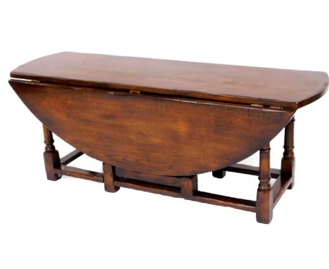 An oak low coffee table, with two gate leg sides, on bobbin turned legs, 47cm high, 112cm long, 40cm wide when closed, 100cm 