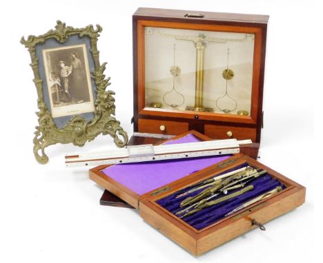 A mahogany cased brass table scale, with articulated front revealing a glazed fronted scale above two drawers, with visible b