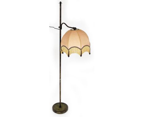 A metal framed adjustable standard lamp, with plain cylindrical stem on circular foot, with peach shade, tassel drops, 158cm 