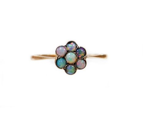 An opal daisy ring, the small daisy cluster set with an arrangement of opals, in yellow metal setting, on a pierced basket, u