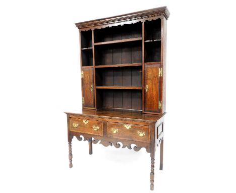 A George III oak dresser, the top with moulded cornice, fretwork frieze, three shelf design to centre, two shelf and single c