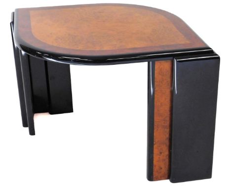 An Art Deco design coffee table, of shaped ellipse form, with a burr wood top and wide cross banding on double stepped legs, 