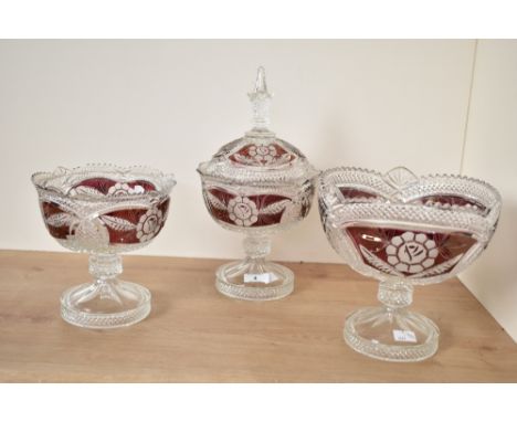 A cut glass pedestal bowl with cover, decorated with floral patterns on a cranberry colour ground, h20.5cm, sold together wit