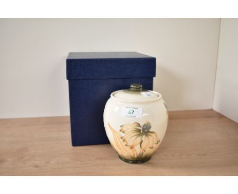 A Moorcroft pottery Cornflower pattern lidded jar, decorated with floral patterns on a cream ground, painted marks to base, d