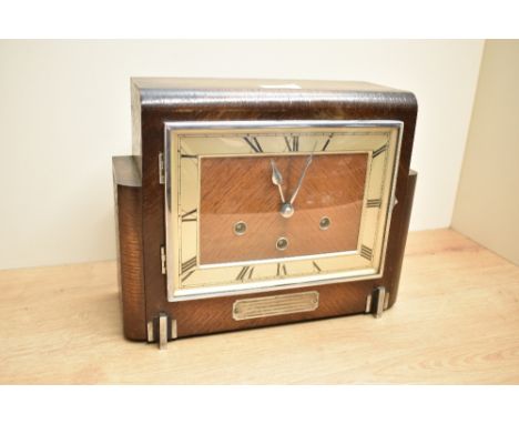An Art Deco style oak cased mantel clock having brass dial and Roman numerals, L29cm