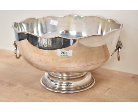 A silver plated punch bowl raised on a stout footed base, decorated with lion mask and ring handles, h19cm