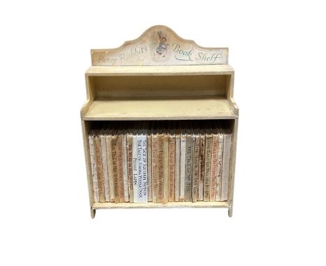 Twenty five volumes 'Beatrix Potter', contained within a painted wooden shelf titled 'The Peter Rabbit's bookshelf'.