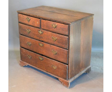 A George III Oak Chest of two short and three long drawers with brass handles and escutcheons raised upon bracket feet, 93 cm
