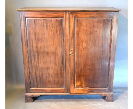 A 19th Century Mahogany Dwarf Hall Cupboard with two panelled doors raised upon bracket feet, 128 cms wide, 43 cms deep, 130 