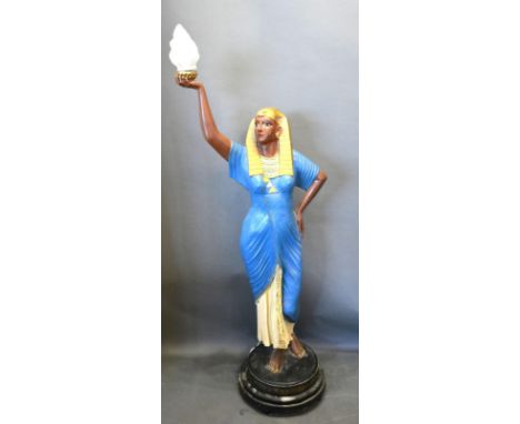 A Floor Standing Lamp Standard in the form of an Egyptian Figure holding a Torch with circular black plinth, 190 cms tall 