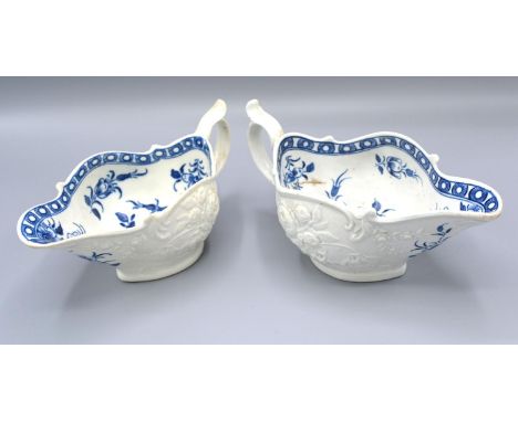A First Period Worcester Jug decorated in relief and underglaze blue, 18 cms long together with another similar, 16.5 cms lon