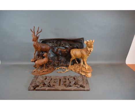 A 19th Century Black Forest Folding Book Stand together with two similar carved models of Stags and a similar carved panel 