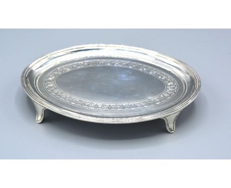 A George III Silver Teapot Stand of oval engraved form with four scroll feet, London 1805, maker Thomas Robins, 3 ozs. 12 x 1