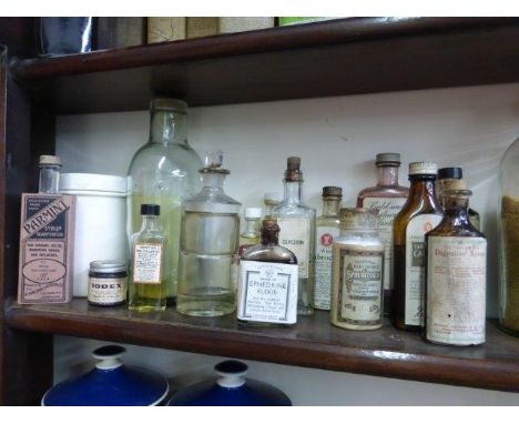 Fifteen glass medicine bottles and a ceramic lidded canister.