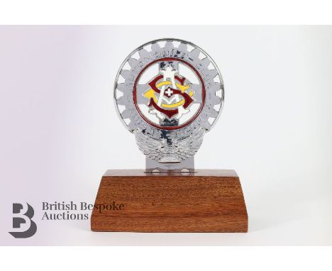 A three-colour enamel and chrome double-sided grille badge for the Suisse Automobile Club, supported on an oak plinth, approx