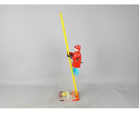 Marx - An unboxed tinplate and plastic 'Climbing Fireman' by Marx. The toy is in Playworn condition. 
