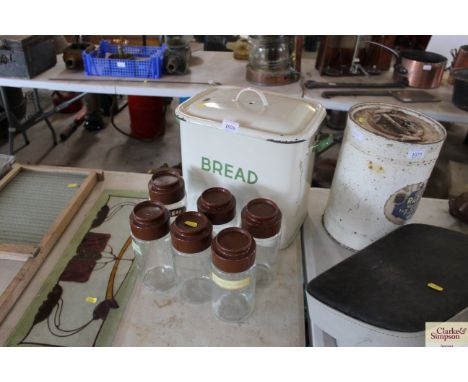 An enamel bread bin and six glass storage jars