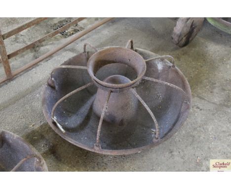 A circular cast iron pig trough with dividers AF