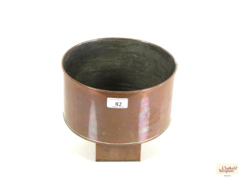 A copper planter on shaped base