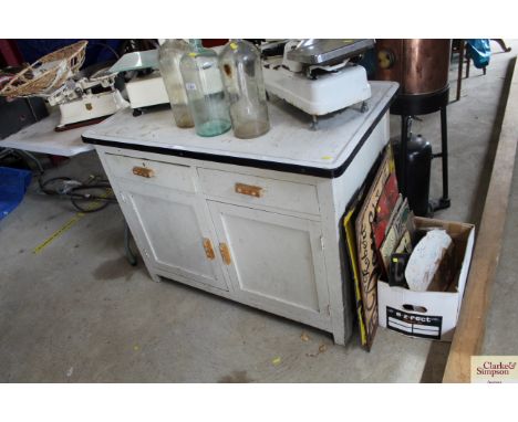 A vintage wooden and enamel topped kitchen cabinet. Width 25”. Height 31”.&nbsp;Length 42.5”
