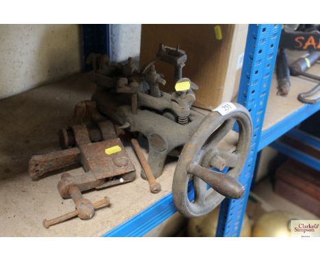 An Oliver Machinery Co. Manchester bench mounting tool and a miniature bench mounting leg vice