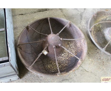 A circular cast iron pig trough with dividers