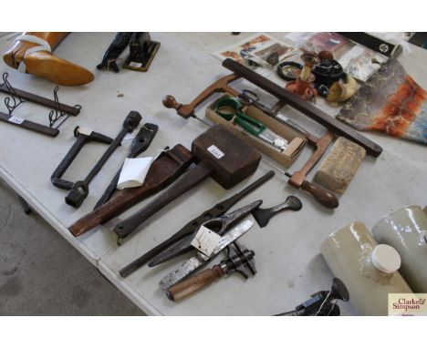 A collection of small hand tools including a saw, wooden mallet, upholstery web strainer, various tool heads etc.