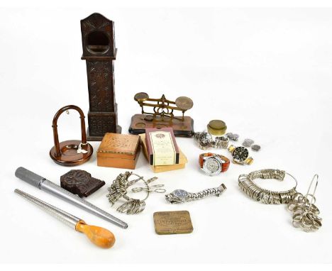 A carved miniature longcase clock pocket watch holder, two further pocket watch holders, a set of balance scales, wax seals, 