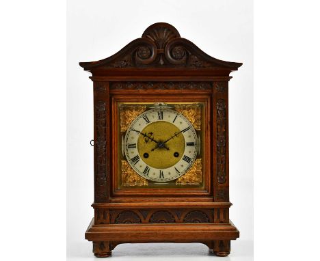 A late 19th/early 20th century German carved walnut bracket clock, the applied chapter ring set with Roman numerals, height 4