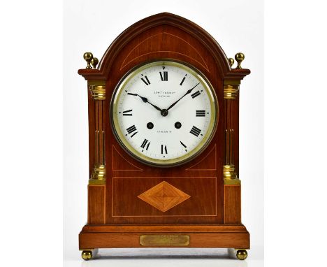 S SMITH &amp; SONS LTD, LONDON; an Edwardian inlaid mahogany arch topped mantel clock with four brass finials, the enamelled 